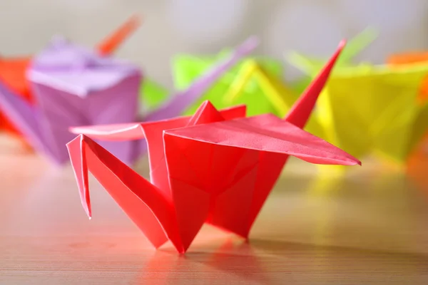 Γερανοί origami στο ξύλινο τραπέζι, επάνω ελαφρύς υπόβαθρο — Φωτογραφία Αρχείου