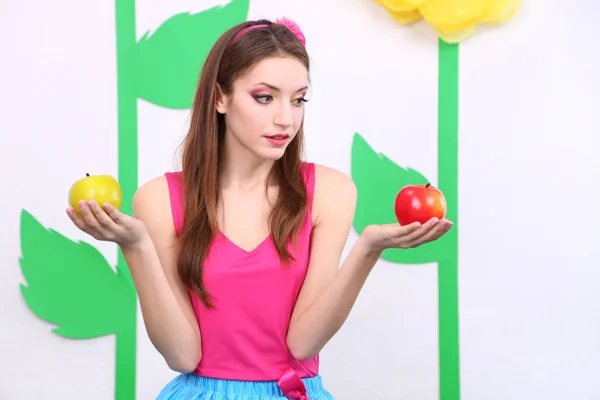 Красивая молодая женщина держит яблоки вблизи — стоковое фото