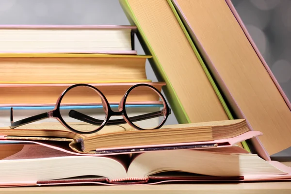 Samenstelling met glazen en boeken, op tafel, op lichte achtergrond — Stockfoto