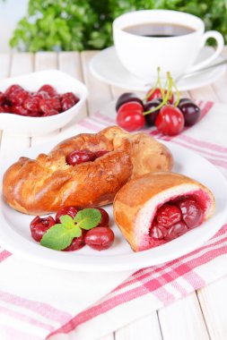 Tablo yakın çekim tabağa kiraz ile taze pişmiş pasties