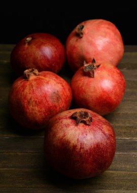 Masanın üzerinde olgun narlar var.