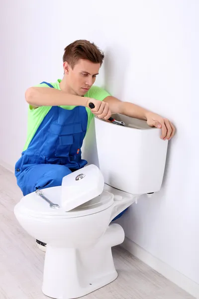 Plombier avec piston de toilette sur fond clair — Photo