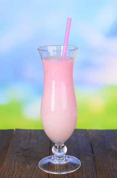 Milk shake on table on light blue background — Stock Photo, Image