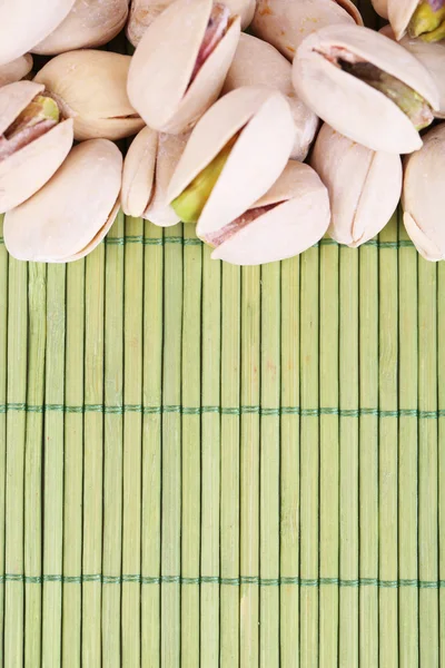 Nueces de pistacho sobre fondo de bambú —  Fotos de Stock