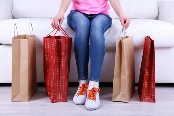 Kadın kanepe yakın çekim alışveriş torbaları ile oturmak — Stok fotoğraf