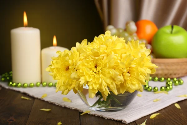 Mooie chrysant bloemen in vaas op tafel op donkere gele achtergrond — Stockfoto