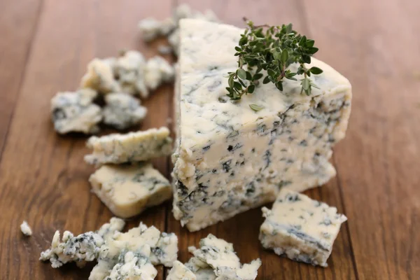 Schmackhafter Blauschimmelkäse mit Thymian, auf Holztisch — Stockfoto