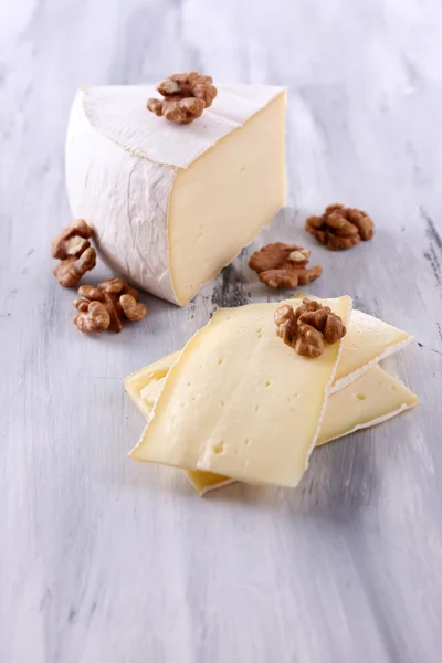 Queijo saboroso Camembert com nozes, sobre mesa de madeira — Fotografia de Stock