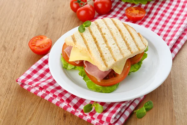 Leckeres Sandwich mit Schinken auf Holztisch — Stockfoto