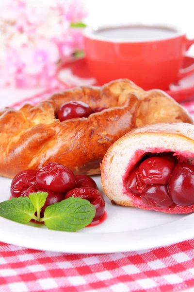 Fresh baked pasties with cherry on plate on table close-up — Stock Photo, Image