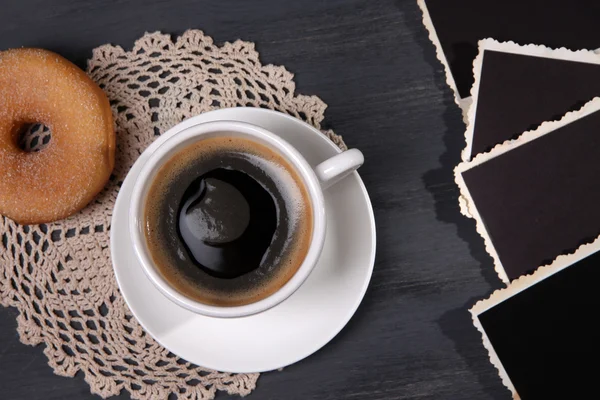 Tazza di caffè, ciambella e vecchie foto in bianco, su sfondo di legno — Foto Stock