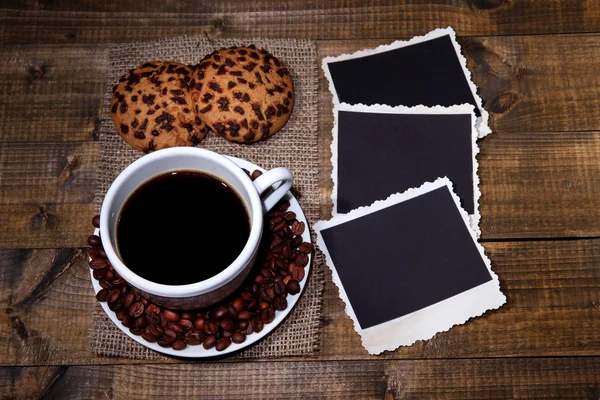 Taza de café, galletas y viejas fotos en blanco, sobre fondo de madera — Foto de Stock