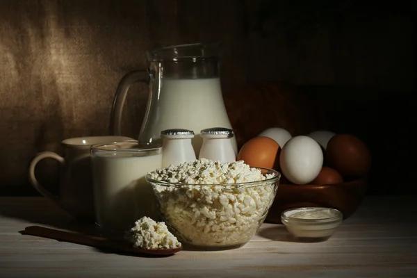 Смачні молочні продукти на дерев'яному столі, на мішковому фоні — стокове фото