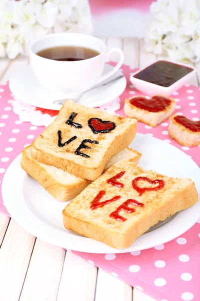 Delicioso brindis con mermelada y taza de té en primer plano de la mesa — Foto de Stock