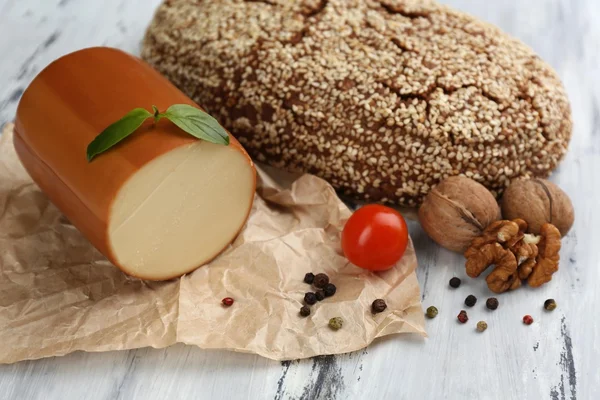 Leckerer Räucherkäse und Brot auf Holztisch — Stockfoto