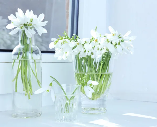 Vackra Buketter av snödroppar i vaser på fönsterbräda — Stockfoto