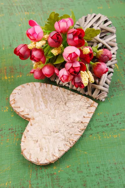 Corazones decorativos y flores sobre fondo de madera de color — Foto de Stock