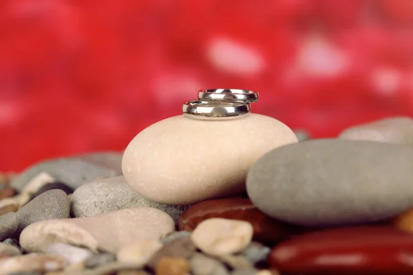 Jegygyűrű, sziklák, piros háttér — Stock Fotó