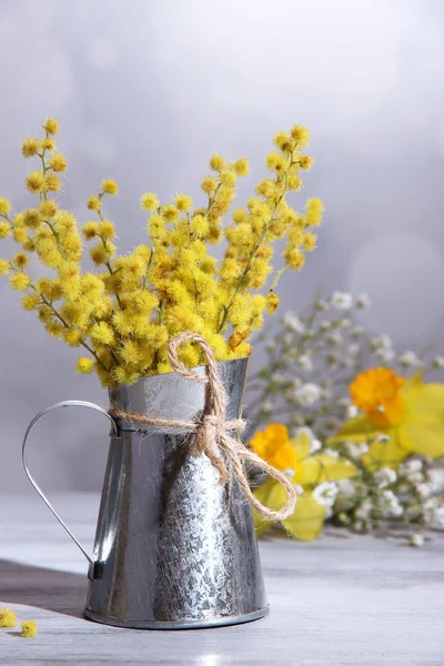 Kvistar av mimosa blommor i vas på träbord — Stockfoto