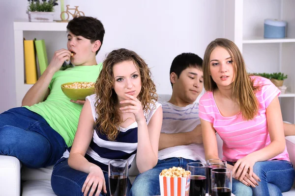 Groupe de jeunes amis regardant la télévision à la maison — Photo