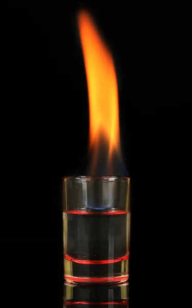 Vidro com álcool em chamas no fundo preto — Fotografia de Stock