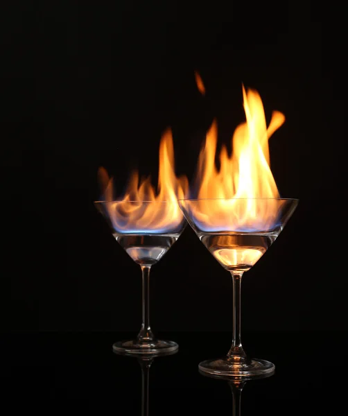 Bicchieri con alcool bruciante su sfondo nero — Foto Stock