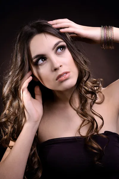 Hermosa joven con el pelo largo sobre fondo marrón oscuro — Foto de Stock