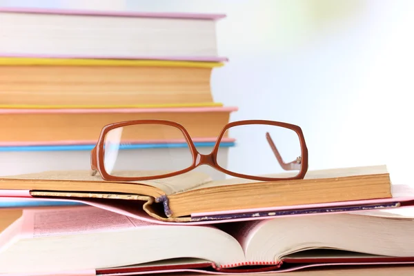 Composition with glasses and books, on table, on light background — Stock Photo, Image