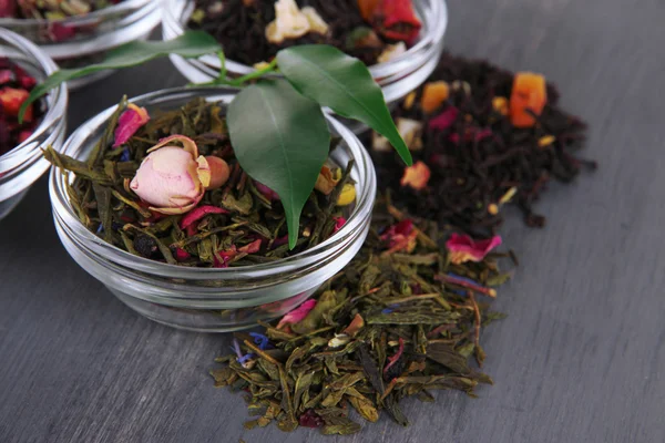 木製の背景にボウルで芳香族の乾燥茶 — ストック写真