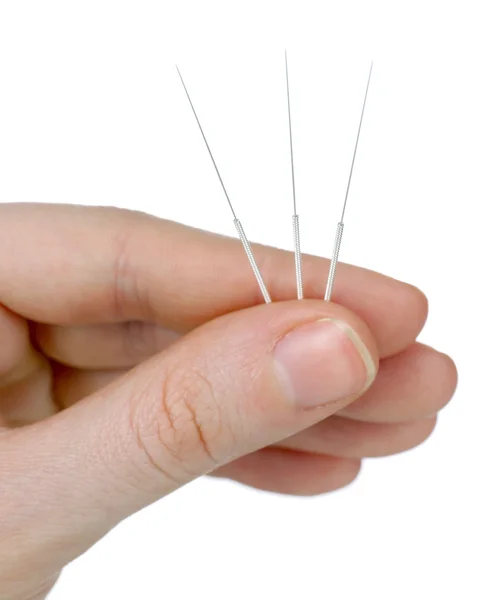 Mão segurando agulhas para acupuntura na mão, de perto. Isolado em branco — Fotografia de Stock