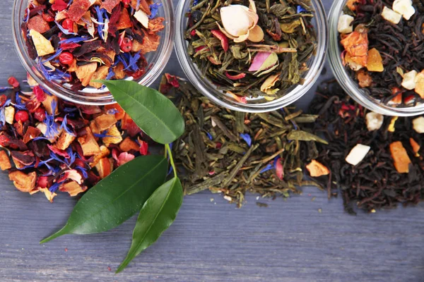 Aromatický suchý čaj v miskách na dřevěné pozadí — Stock fotografie