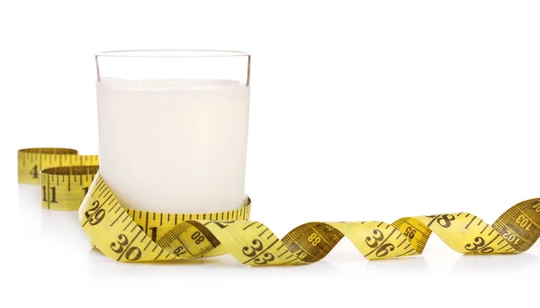 Glass of milk with measuring tape isolated on white — Stock Photo, Image