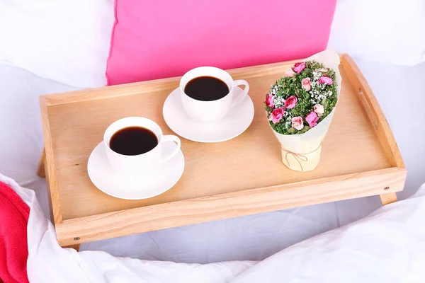 Tassen Kaffee auf bequemen weichen Bett mit Kissen — Stockfoto