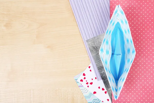 Origami barco y papeles de color en mesa de madera — Foto de Stock