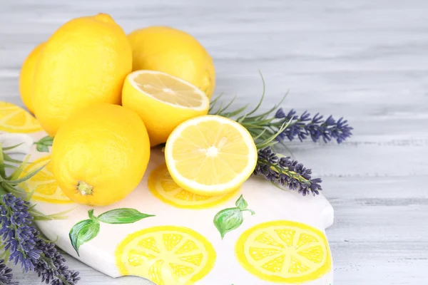 Натюрморт со свежими лимонами и лавандой на деревянном столе — стоковое фото
