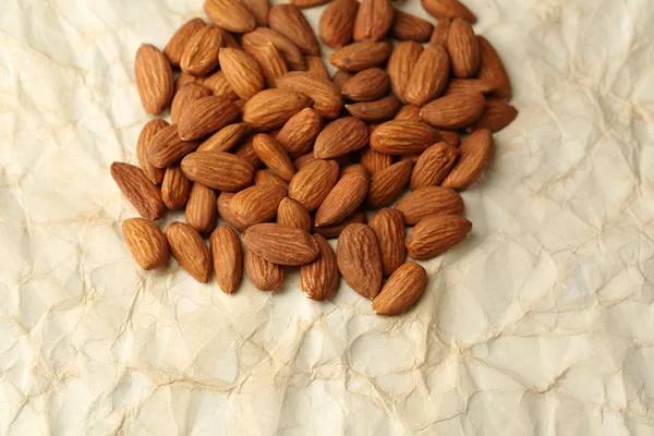 Almonds on old paper background — Stock Photo, Image