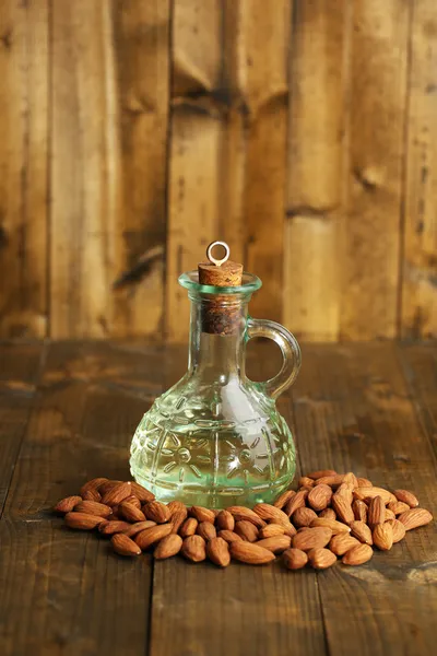 Bouteille à l'huile d'amandes sur fond en bois de couleur — Photo