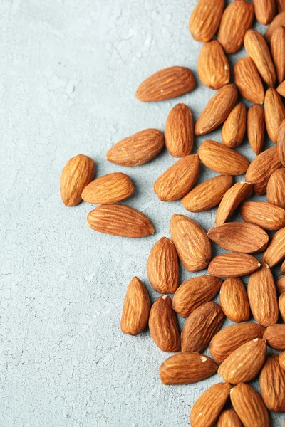 Almonds on color wooden background — Stock Photo, Image