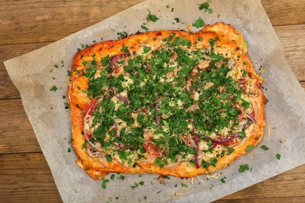 Pizza casera sobre papel de hornear de cerca — Foto de Stock