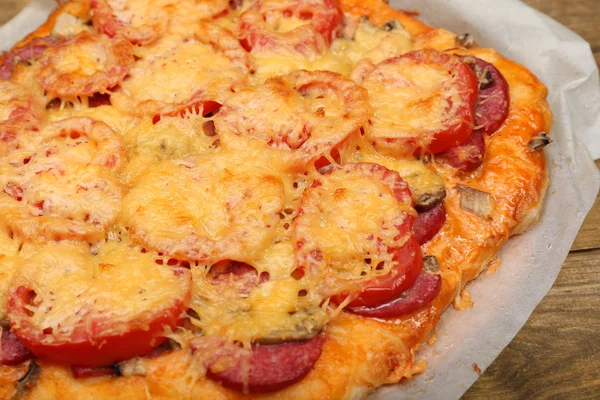 Homemade pizza on baking paper close up — Stock Photo, Image