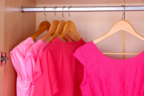 Female clothes on hangers in wardrobe — Stockfoto