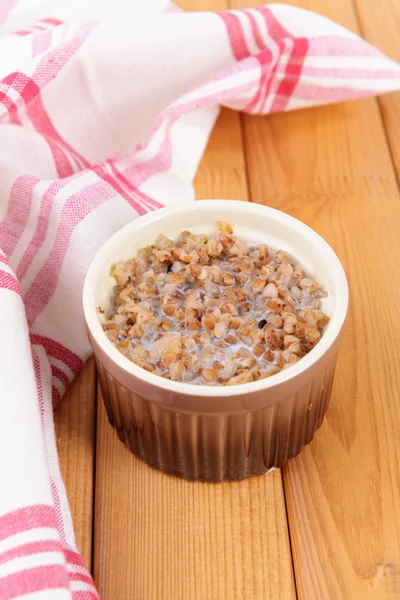Boiled buckwheat with milk in bowl on table close-up — Stock Photo, Image