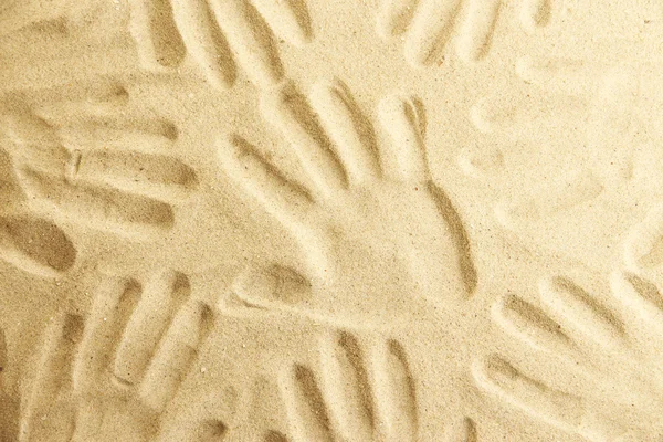 Hand prints in sand as nice summer background — Stock Photo, Image