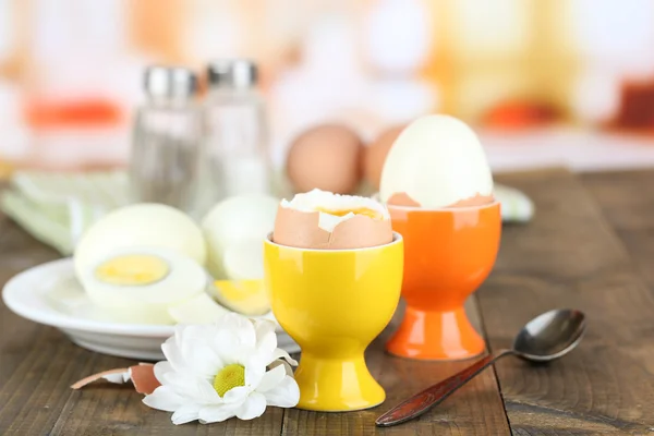 Huevos cocidos en la mesa de madera de color, sobre fondo brillante — Foto de Stock