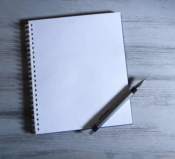 Notebook with pen on color wooden background — Stock Photo, Image