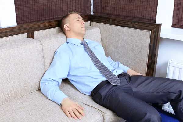 Jonge zakenman rusten op Bank in office — Stockfoto