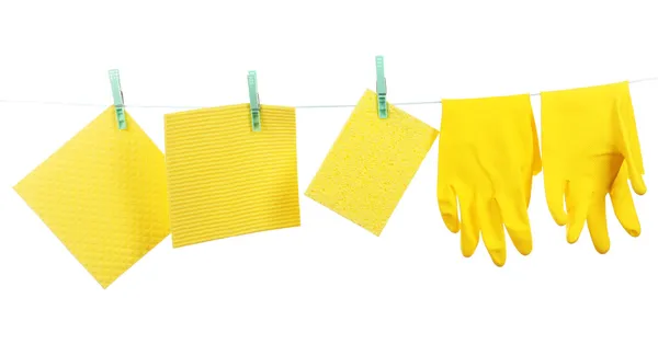 Kitchen sponges and rubber gloves hanging on rope isolated on white — Stock Photo, Image