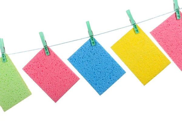 Kitchen sponges hanging on rope isolated on white — Stock Photo, Image