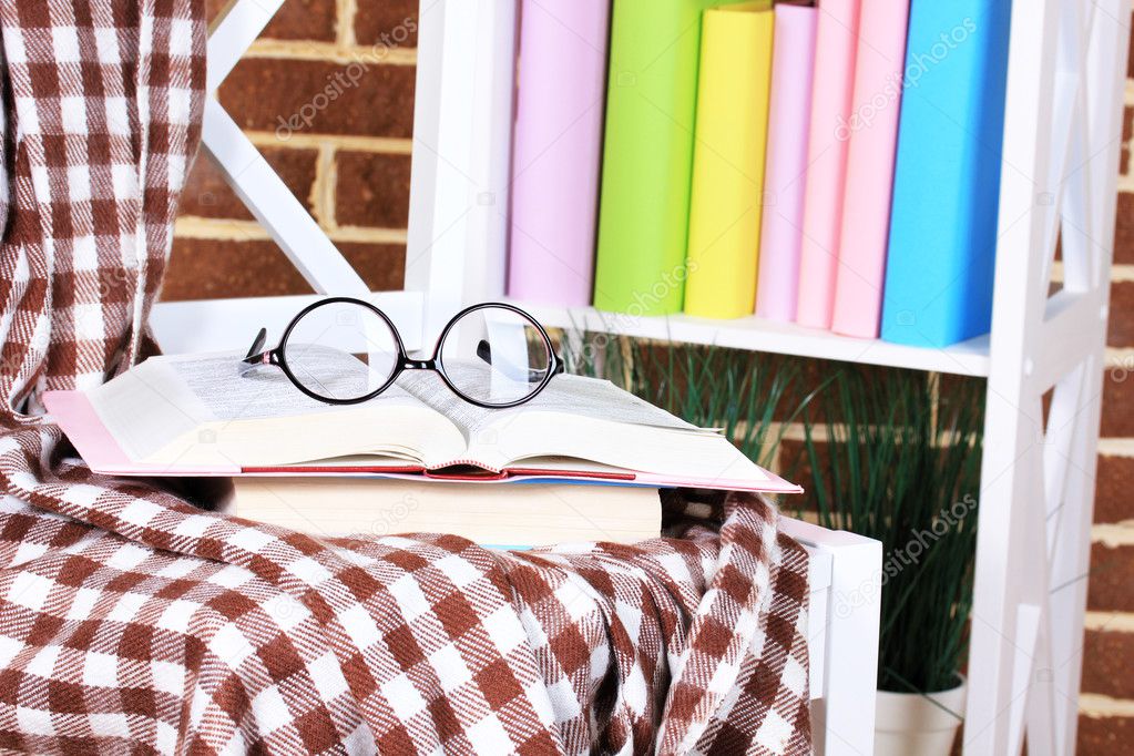Composition with glasses and books, on chair, on cabinet and wall background