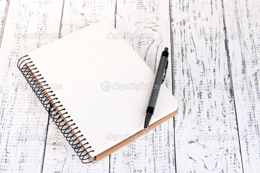 Notebook with pen on color wooden background